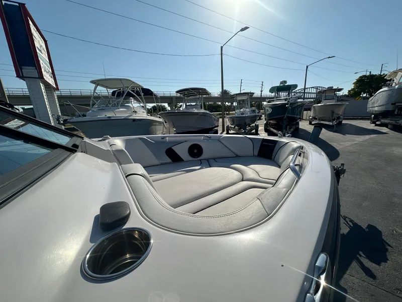 Slide: The Image of 2010 Nautique Super Air Nautique 230 boat, front seating area, docked with other boats. - 6