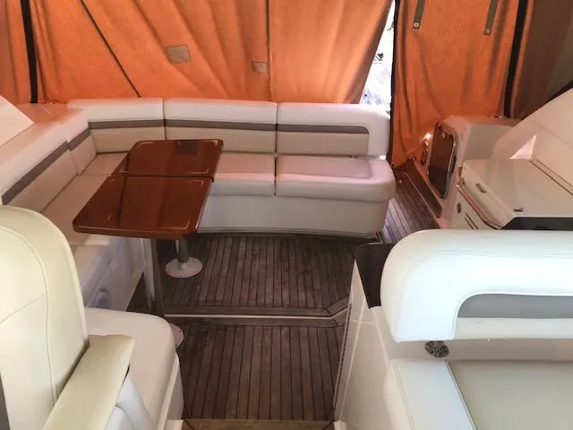 Slide: The Image of Interior of 2013 Sea Ray 470 Sundancer with white seating and wooden table. - 13
