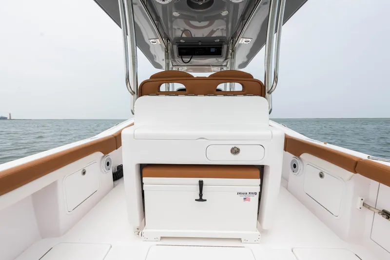Slide: The Image of 2022 Mag Bay 33cc boat interior with seating and storage, ocean in the background. - 15