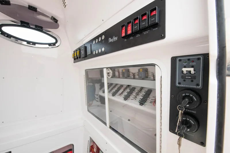Slide: The Image of Control panel and storage area inside a 2022 Mag Bay 33cc boat. - 16