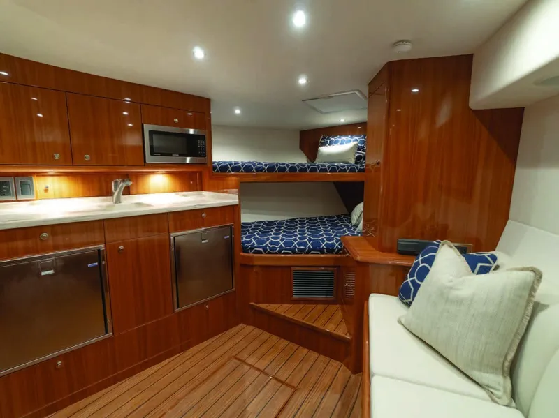 Slide: The Image of 2025 Viking 38 Open Billfish interior with kitchen, bunk beds, and seating area. - 1