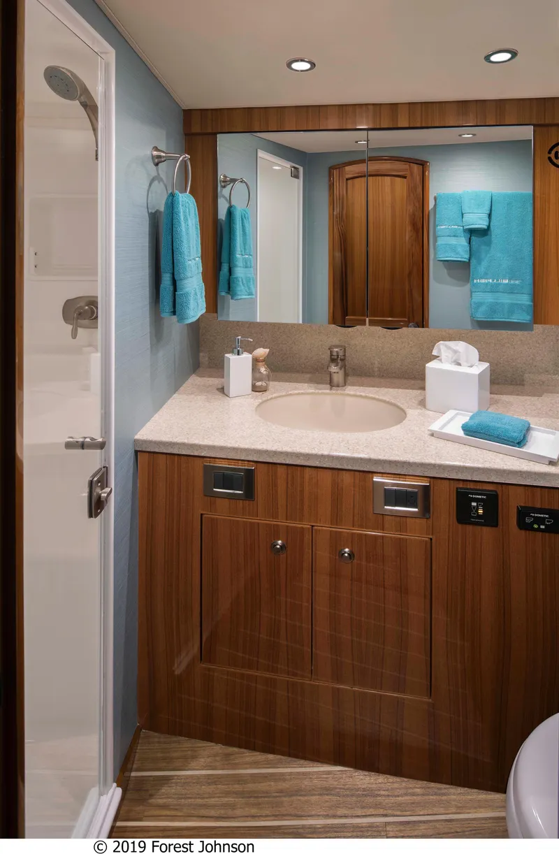 Slide: The Image of 2025 Viking 38 Billfish bathroom with modern fixtures and wooden cabinetry. - 2