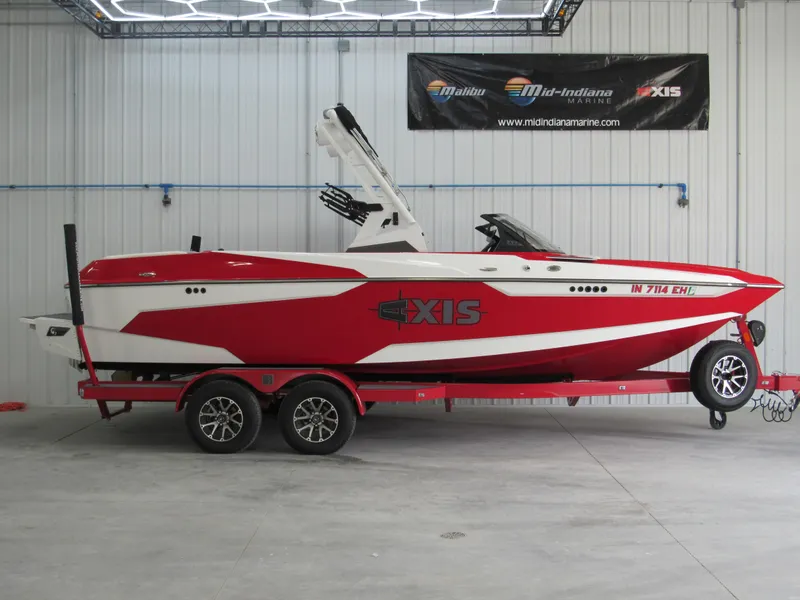 Slide: The Image of 2022 Axis A22 red and white boat on trailer in showroom. - 0