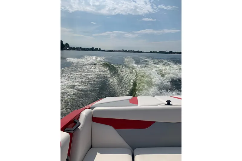 Slide: The Image of 2022 Axis A22 boat cruising on a sunny lake, leaving a wake behind. - 19