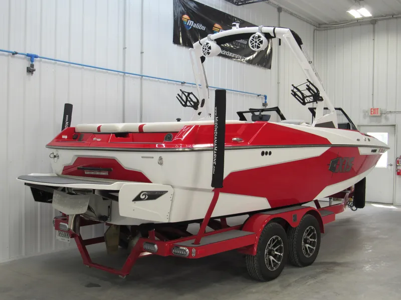 Slide: The Image of 2022 Axis A22 red and white wakeboard boat on a matching trailer in a garage. - 3