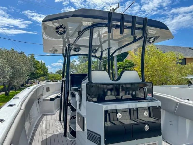 Slide: The Image of 2023 AMP Arth 333 boat with modern console and seating under a clear blue sky. - 13