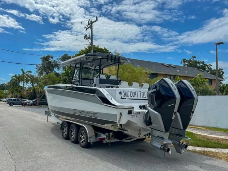 Slide: The Image of AMP Arth 333 boat 2023 model on a trailer with dual outboard motors. - 2