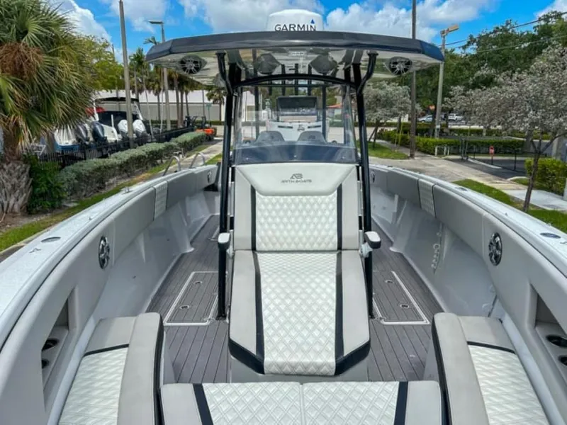 Slide: The Image of 2023 AMP Arth 333 boat interior with white cushioned seating and Garmin navigation system. - 7