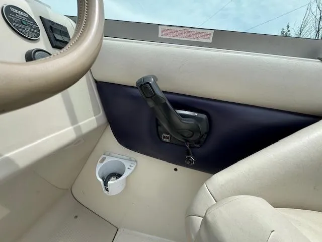 Slide: The Image of Interior of a 1995 Regal 256 Commodore boat showing steering wheel and throttle control. - 16