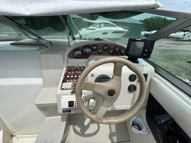 Slide: The Image of 1995 Regal 256 Commodore boat cockpit with steering wheel and control panel. - 19