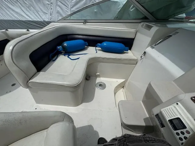 Slide: The Image of 1995 Regal 256 Commodore boat interior with white seating and blue fenders. - 23