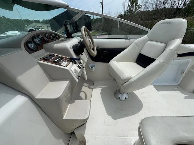 Slide: The Image of 1995 Regal 256 Commodore boat cockpit with steering wheel and captain's chair. - 28
