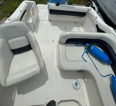 Slide: The Image of 1995 Regal 256 Commodore boat interior with white seating and blue fenders. - 31