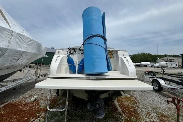 Slide: The Image of 1995 Regal 256 Commodore boat in storage yard with blue rolled mat. - 8