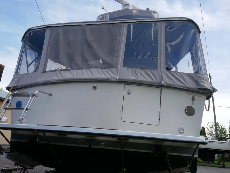 Slide: The Image of 1986 Silverton 40 Convertible boat with enclosed cockpit, docked on land. - 11