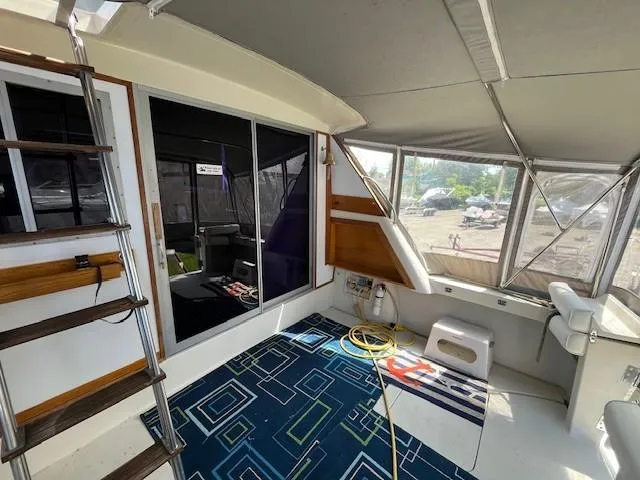 Slide: The Image of 1986 Silverton 40 Convertible boat interior with seating, ladder, and geometric rug. - 14