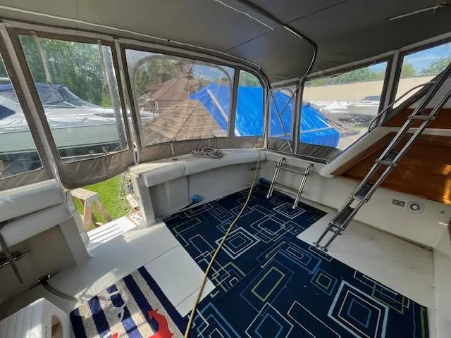 Slide: The Image of 1986 Silverton 40 Convertible boat interior with blue geometric carpet and enclosed seating area. - 16