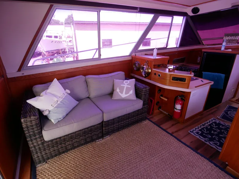 Slide: The Image of Interior of 1986 Silverton 40 Convertible yacht with cozy seating area and nautical decor. - 25