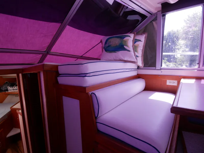 Slide: The Image of 1986 Silverton 40 Convertible interior seating area with cushions and window view. - 34