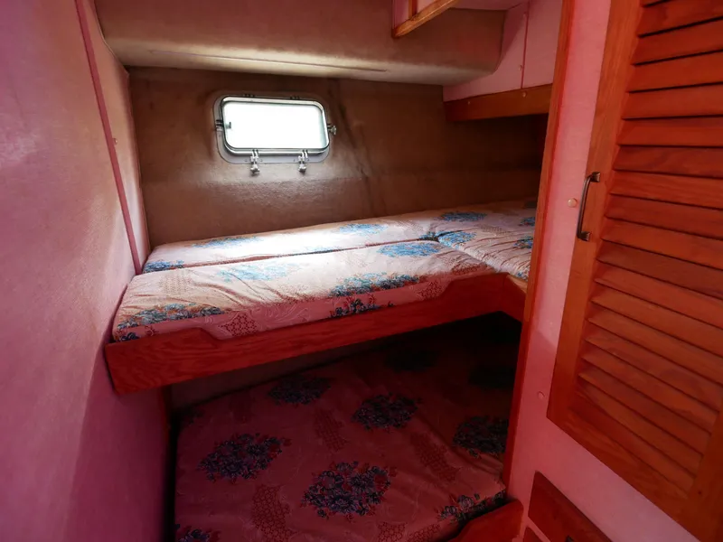 Slide: The Image of 1986 Silverton 40 Convertible cabin with bunk beds and porthole window. - 35