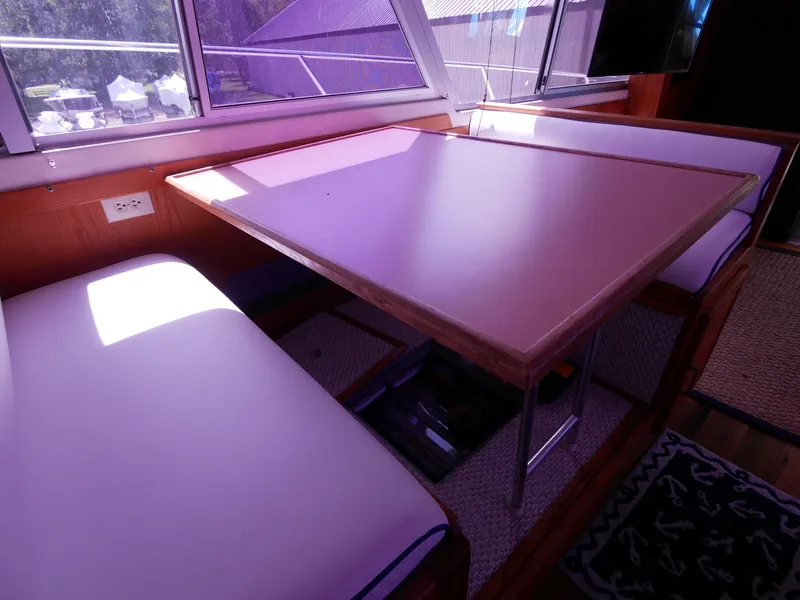 Slide: The Image of Interior dining area of 1986 Silverton 40 Convertible yacht with table and cushioned seating. - 38