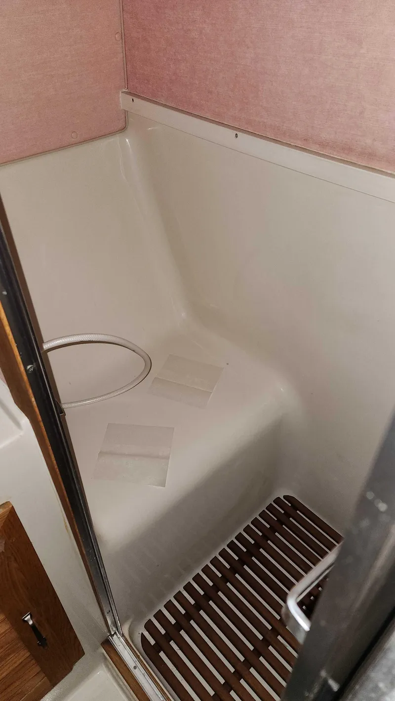 Slide: The Image of 1986 Silverton 40 Convertible boat bathroom with shower and wooden floor mat. - 39