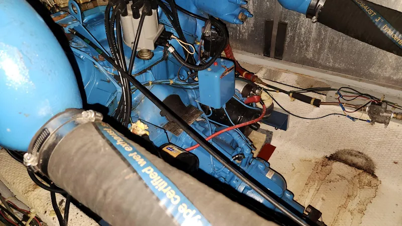 Slide: The Image of Engine compartment of a 1986 Silverton 40 Convertible boat with blue engine components. - 43