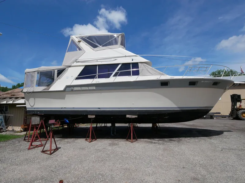 Slide: The Image of 1986 Silverton 40 Convertible boat on stands under a clear blue sky. - 5