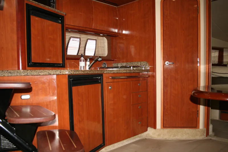 Slide: The Image of Interior of 2006 Sea Ray Sundancer 380 yacht with wooden cabinetry and compact kitchen area. - 19