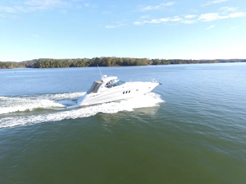 Slide: The Image of 2006 Sea Ray Sundancer 380 cruising on a calm lake under a clear blue sky. - 2