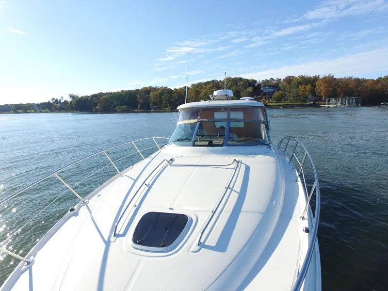 Slide: The Image of 2006 Sea Ray Sundancer 380 yacht cruising on a serene lake with wooded shoreline. - 5