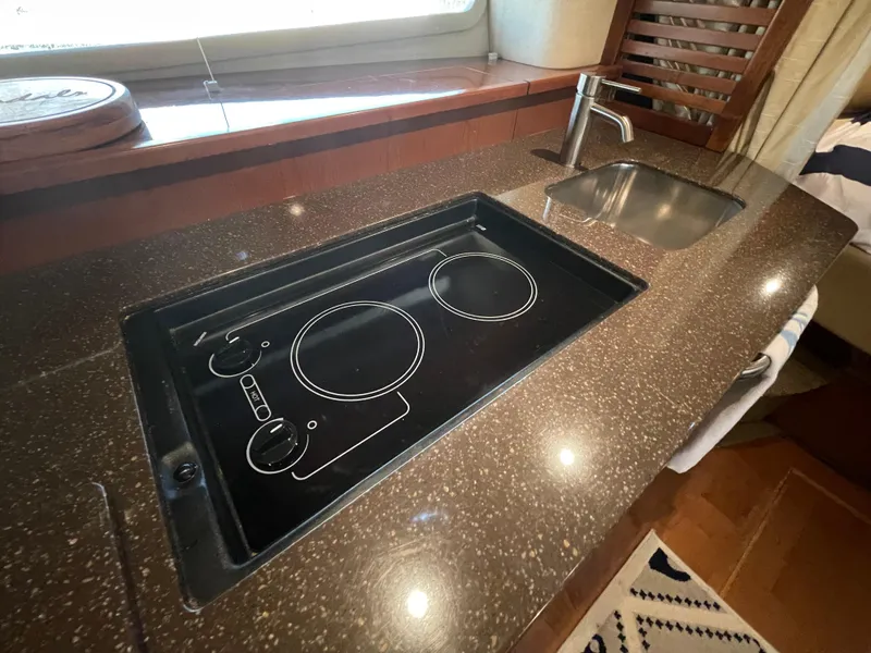Slide: The Image of Modern kitchen area in a 2014 Sea Ray 370 Sundancer yacht with stovetop and sink. - 10