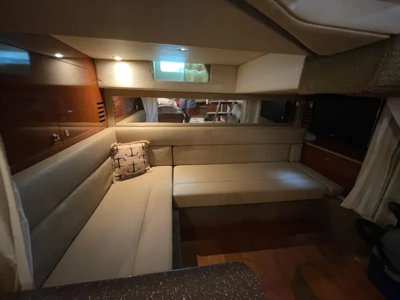 Slide: The Image of Interior of 2014 Sea Ray 370 Sundancer with beige seating and anchor-themed pillow. - 13