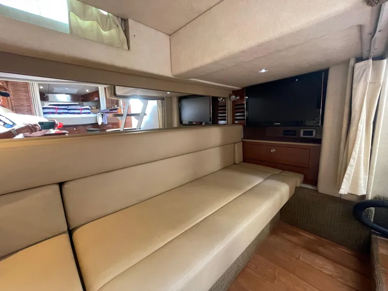 Slide: The Image of Interior of 2014 Sea Ray 370 Sundancer with beige seating and TV. - 14