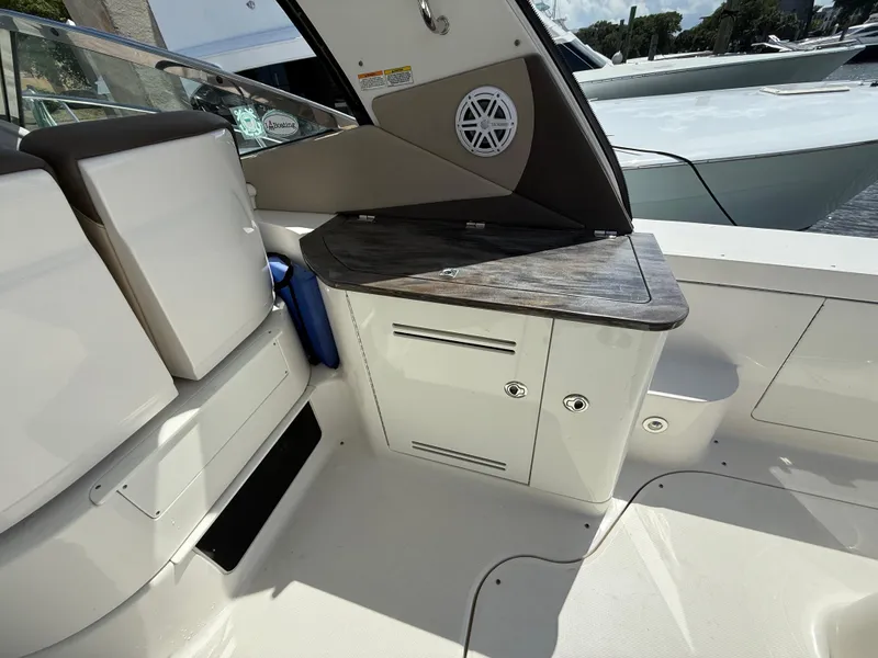 Slide: The Image of 2014 Sea Ray 370 Sundancer cockpit with storage cabinets and seating area. - 18