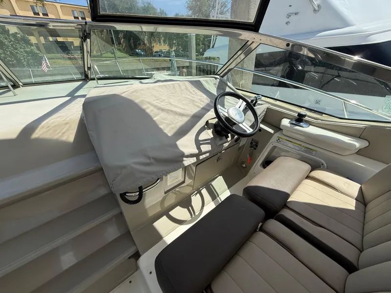 Slide: The Image of 2014 Sea Ray 370 Sundancer helm with covered dashboard and comfortable seating. - 20