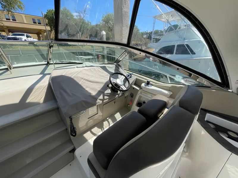 Slide: The Image of Cockpit of 2014 Sea Ray 370 Sundancer with covered helm and black seating. - 22