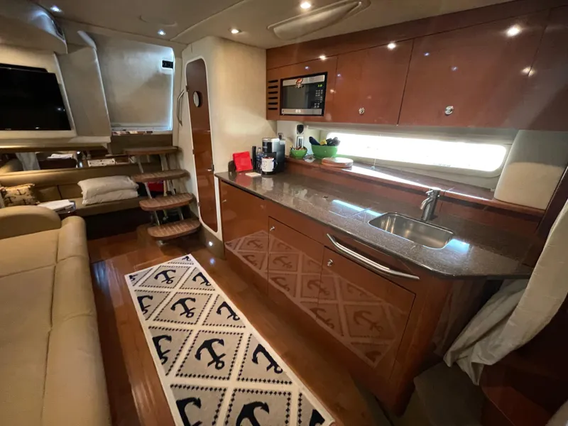 Slide: The Image of Interior of 2014 Sea Ray 370 Sundancer yacht with modern kitchen and cozy seating area. - 8
