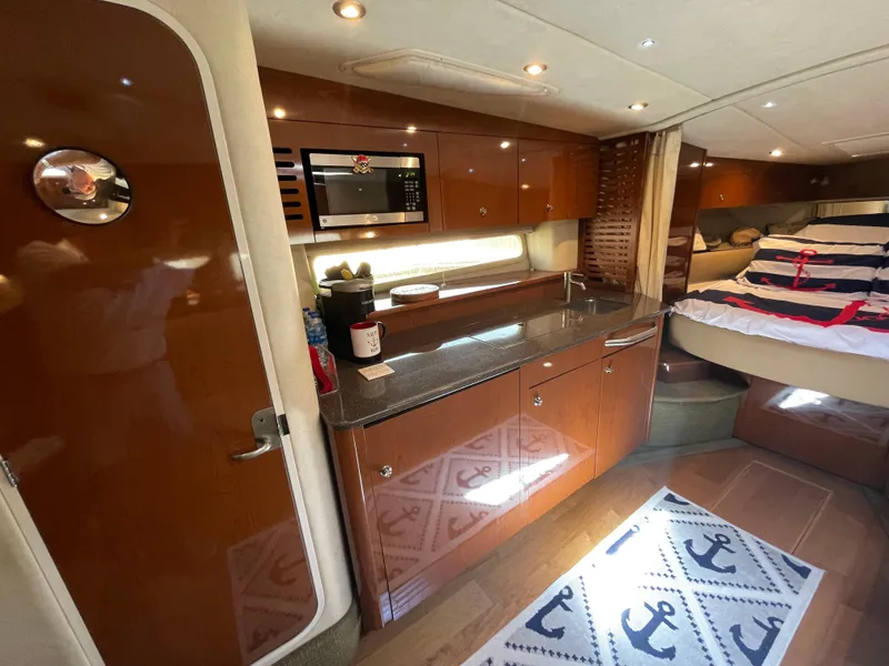 Slide: The Image of Interior of 2014 Sea Ray 370 Sundancer with kitchen and bed area. - 9
