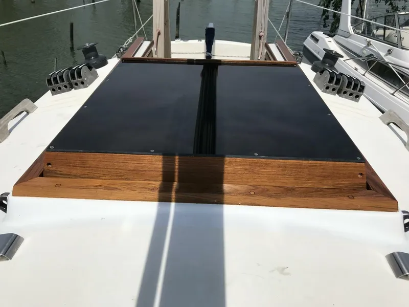 Slide: The Image of 1980 Chrysler S-27 sailboat deck with wooden hatch and sleek design. - 10