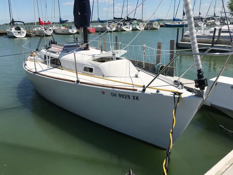 Slide: The Image of 1980 Chrysler S-27 sailboat docked in a marina, surrounded by other boats. - 13