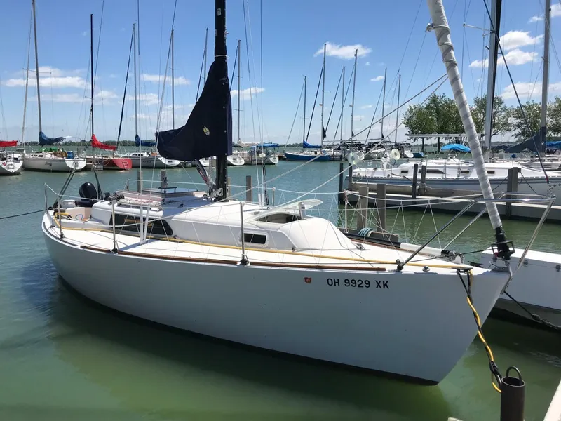 Slide: The Image of 1980 Chrysler S-27 sailboat docked in a marina, surrounded by other boats. - 14