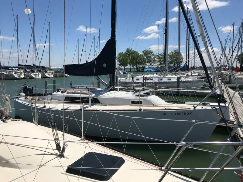 Slide: The Image of 1980 Chrysler S-27 sailboat docked in a marina, surrounded by other boats. - 15