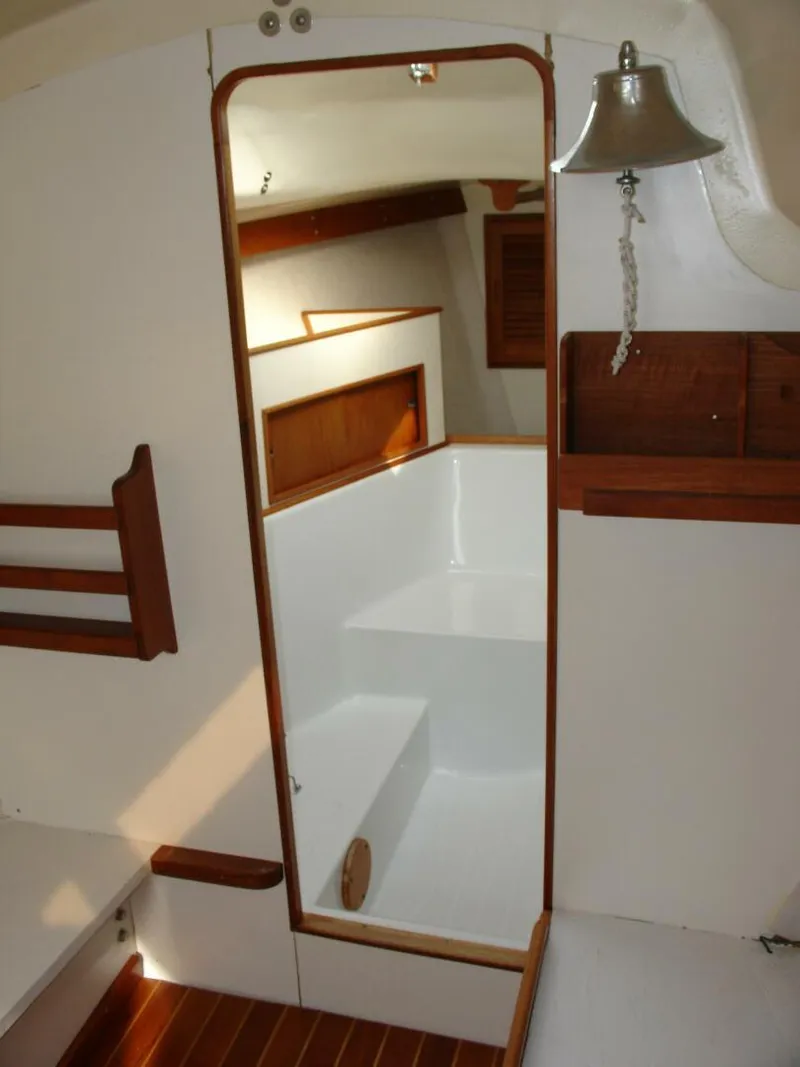 Slide: The Image of 1980 Chrysler S-27 yacht interior with wooden accents and nautical bell. - 18