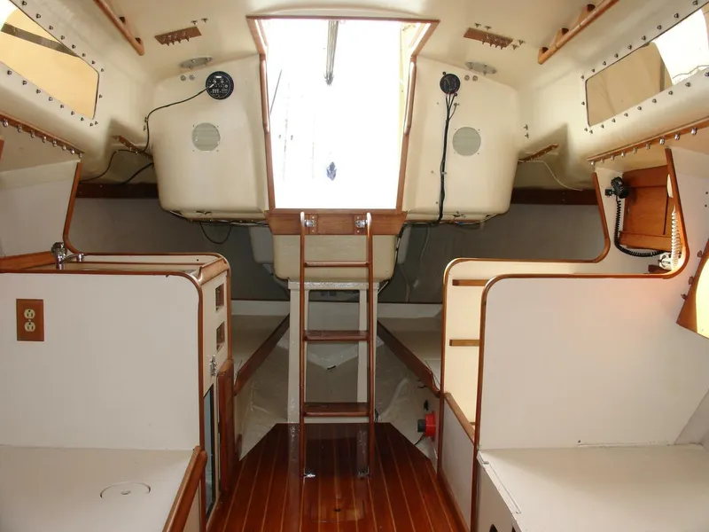 Slide: The Image of Interior of a 1980 Chrysler S-27 sailboat, featuring wooden flooring and compact cabin layout. - 20