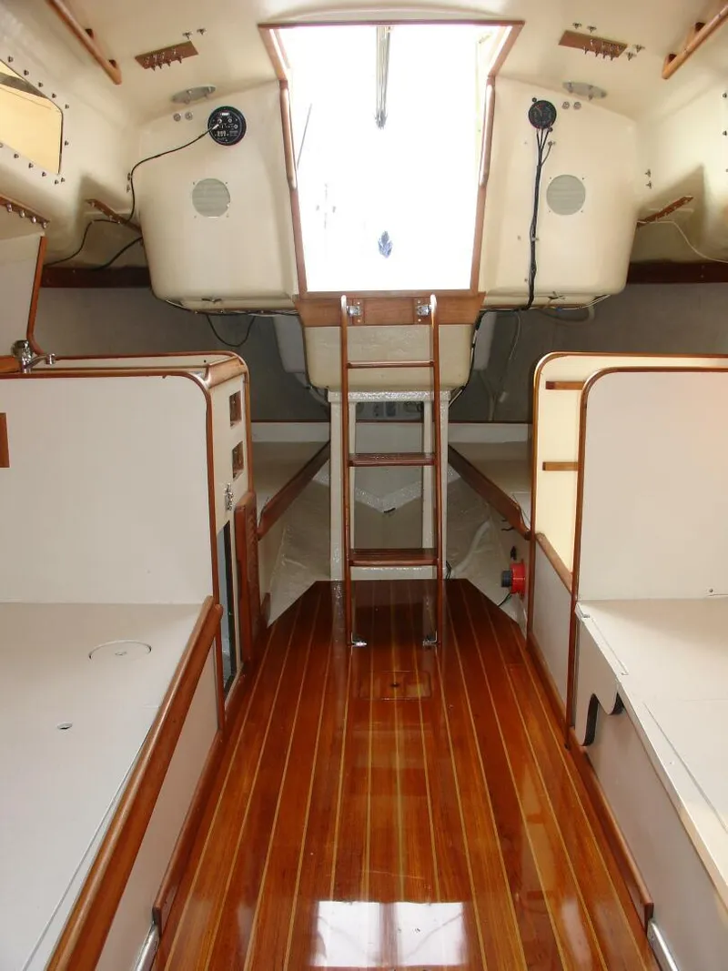 Slide: The Image of 1980 Chrysler S-27 yacht interior with wooden flooring and white cabin walls. - 21