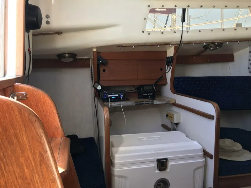 Slide: The Image of Interior of a 1980 Chrysler S-27 sailboat with wooden accents and a white cooler. - 8