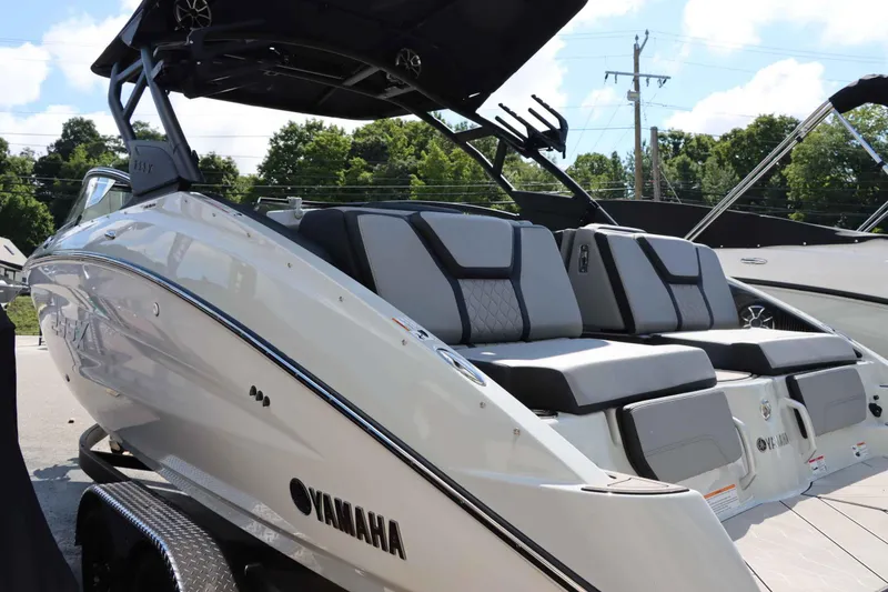 Slide: The Image of 2024 Yamaha Boats 255XE, sleek design, luxury seating, outdoor setting. - 14