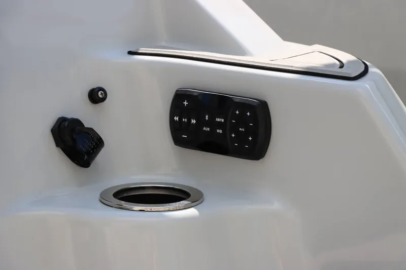 Slide: The Image of 2024 Yamaha Boats 255XE control panel with audio system and cup holder. - 19