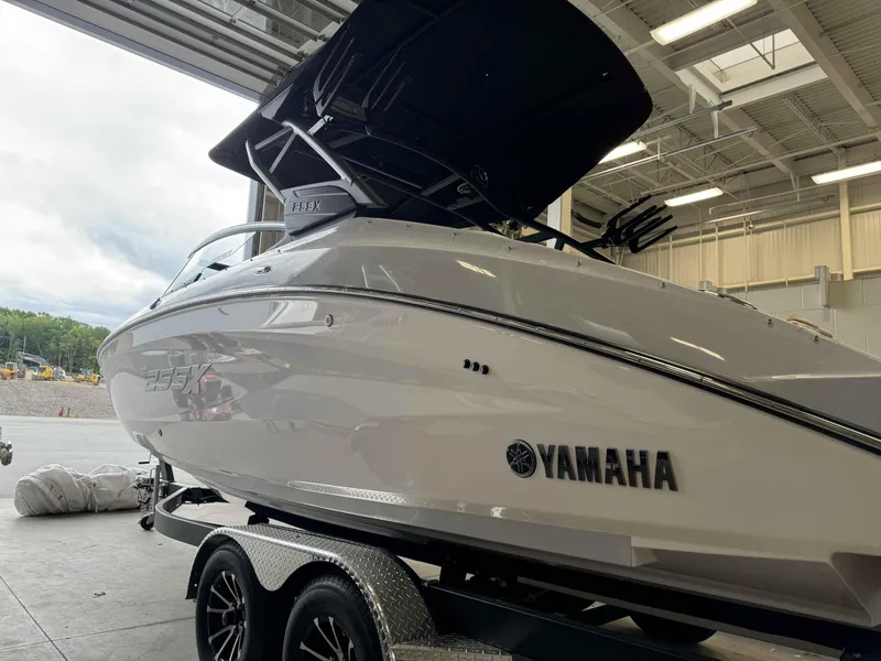 Slide: The Image of 2024 Yamaha Boats 255XE in a showroom, side view on a trailer. - 3